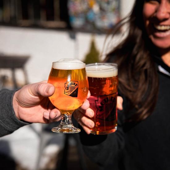 Friends make a toast with glasses of beer from a brewery in Flagstaff. 